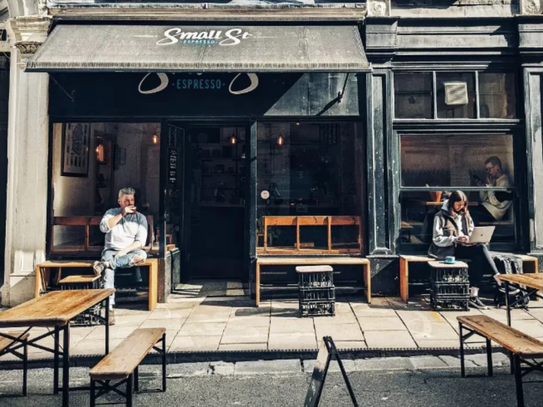 People sitting on the tables outside of Small Street Espresso coffee shop in Bristol