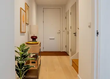 A welcoming entryway with engineered timber flooring and styled with modern furnishings.