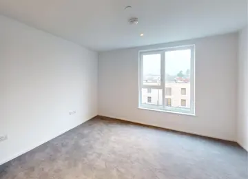 Bedroom with generous window and light grey carpet.