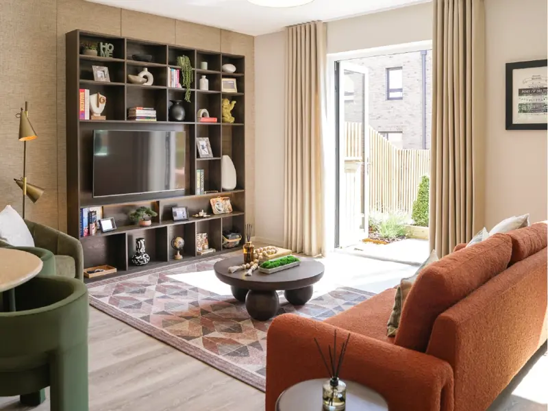 Modern living room featuring a custom TV shelp, orange sofa, patterned rug, and natural light streaming in through open doors.