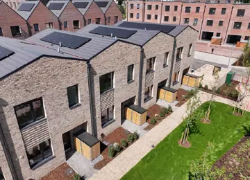 Aerial view of The Skylark house type at Brabazon, a row of modern, two-storey brick townhouses with solar panels, surrounded by a living street. 
