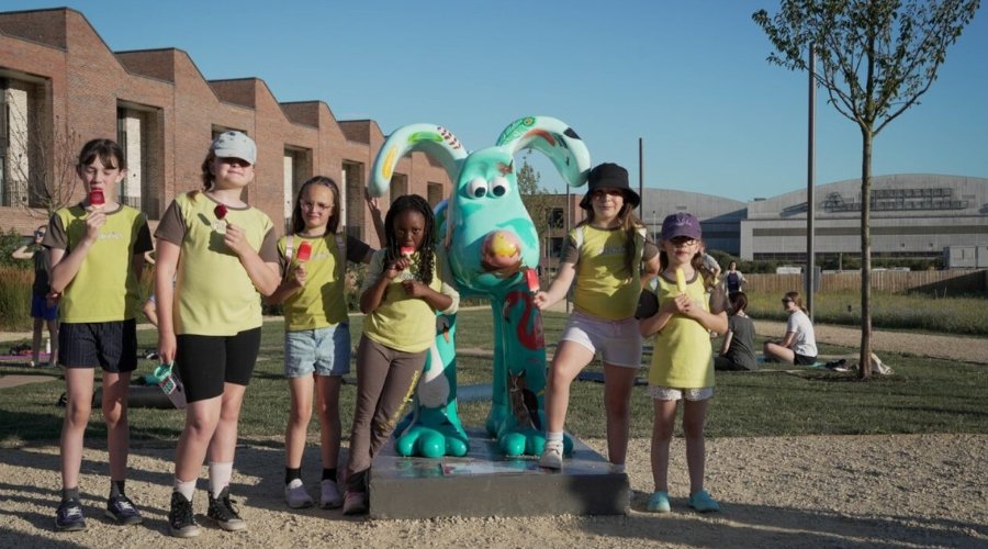 Young girls eating ice lollies pose for a photo next to 'The Birds' Gromit Sculpture at Brabazon.