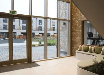 Bright and airy lobby with seating area, leading onto a landscaped garden.