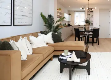 Open-plan living room and kitchen diner flooded with natural light leading in from double height patio doors.