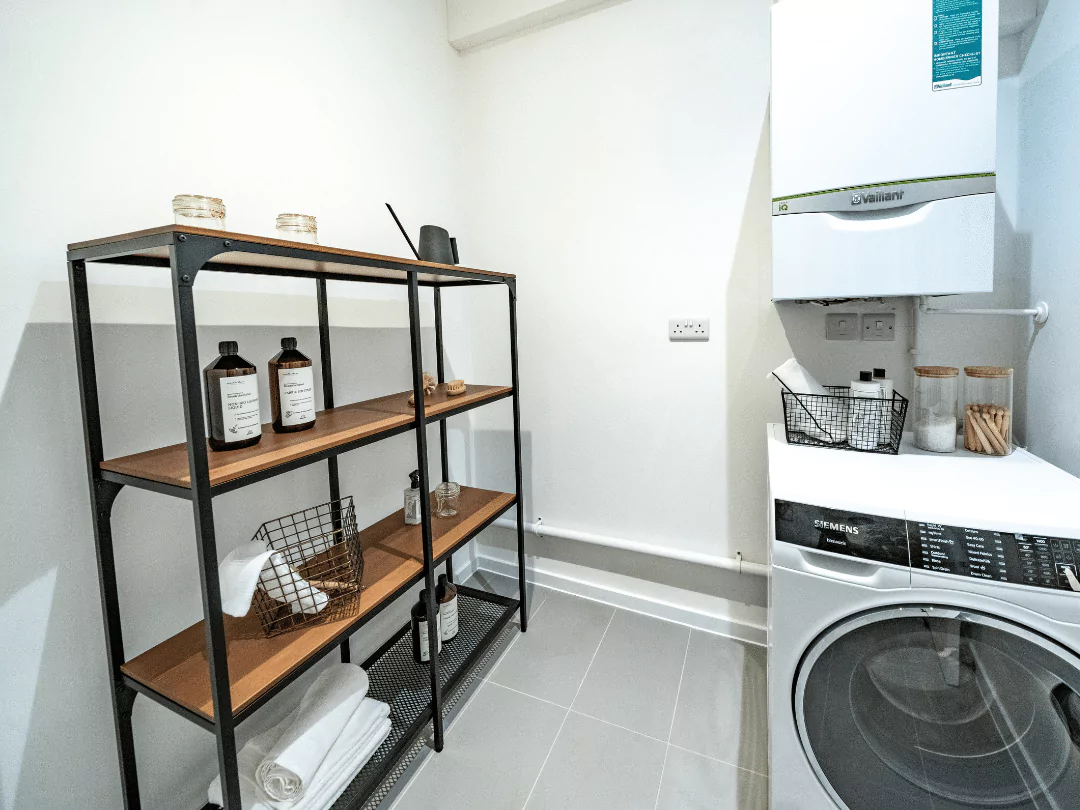 Utility room including the boiler and washing machine, featuring styled shelving.