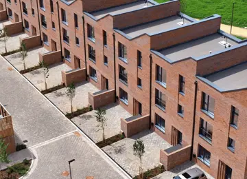 Aerial view of a row of grant four-bedroom, red-brick townhouses with driveways at Brabazon.