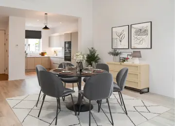 CGI of dining area in The Skylark at Brabazon,  with a round table, charcoal chairs, decorative plants, and framed leaf artwork, in front a modern and minimalistkitchen.