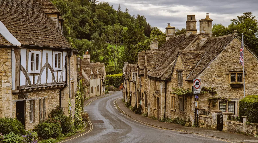 Historic Costwold Stone cottages lining a street in Castle Combe.