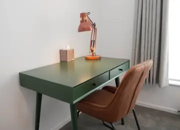 Green desk and green leather chair in secluded study in a new home at Brabazon, Bristol. 
