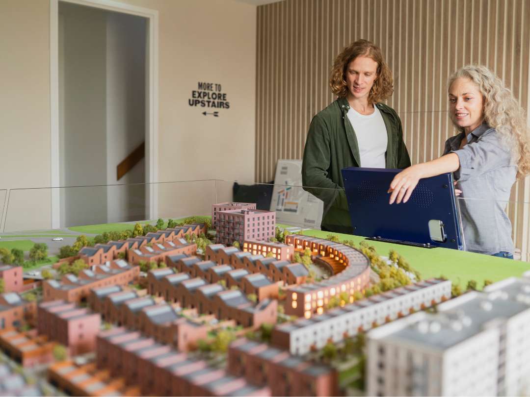 Customers exploring the large Hangar District model within the Brabazon Sales Centre.