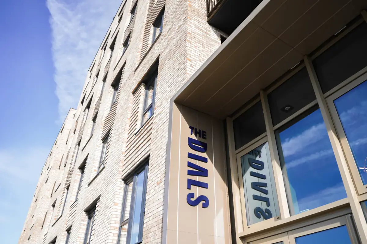 The Dials entrance on Runway Avenue. The Dials sign on the front facade of The Dials apartment building.